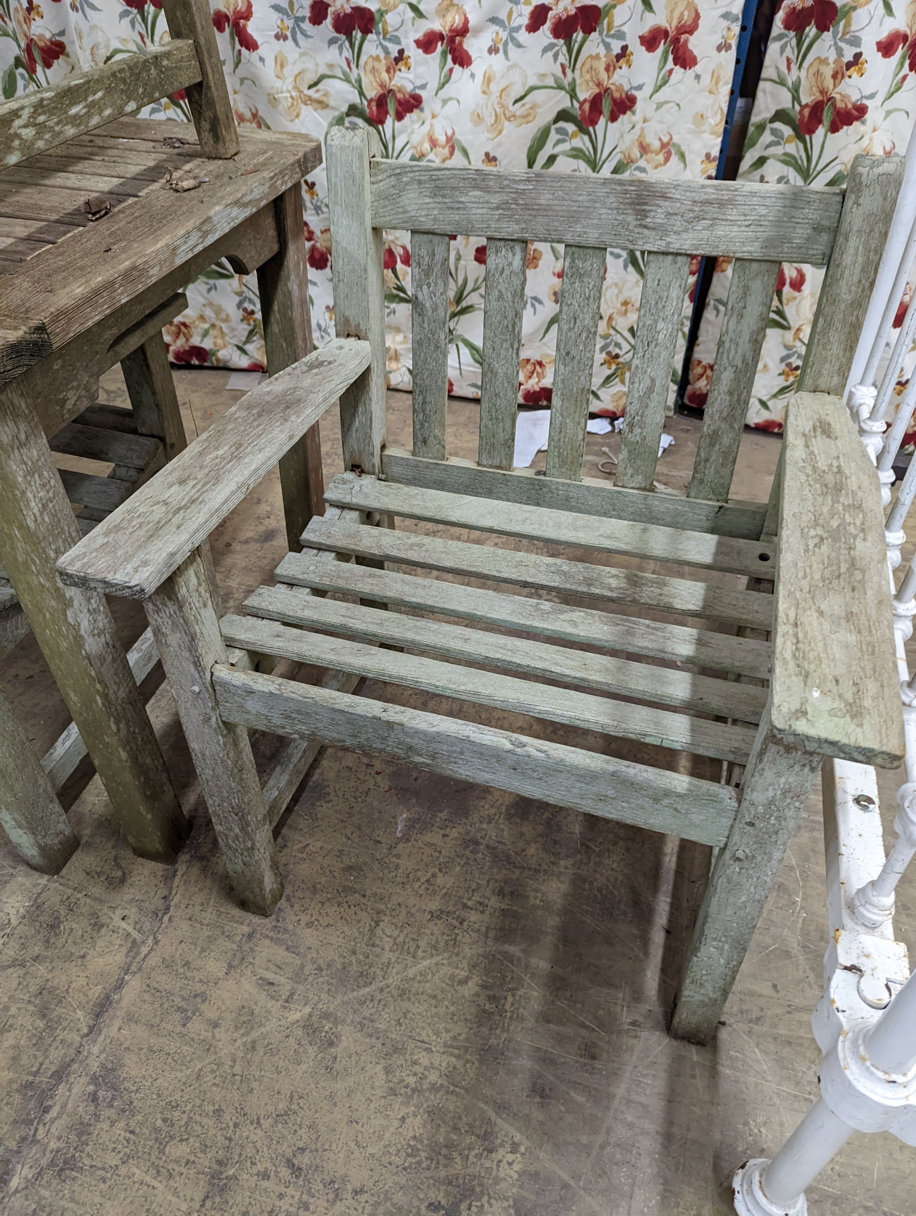 A weathered teak rectangular garden table and six elbow garden chairs, not matching. Table measures, W-149cm, D-70cm, H-75cm.